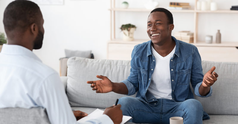 A young man and a counselor in a residential therapy session