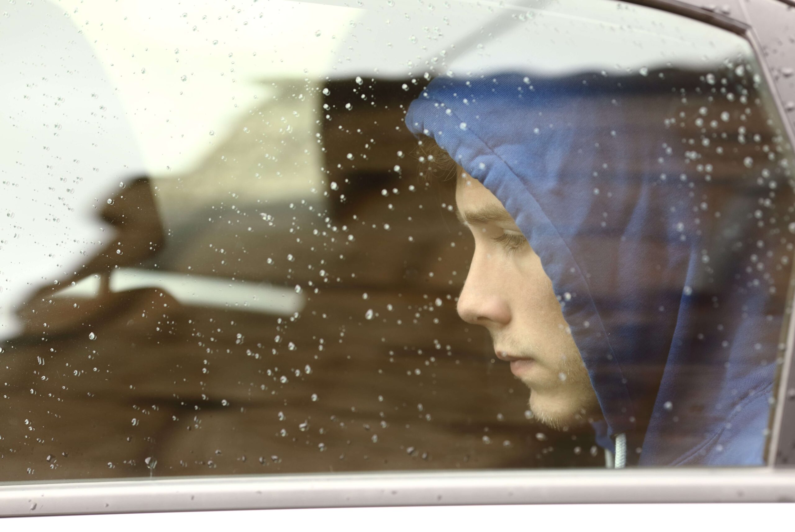 Boy looking sadly through a window, seeking help, Capstone Treatment Center is one of the best rehab centers in Arkansas